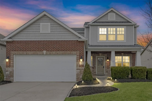 view of front facade with an attached garage, stone siding, driveway, and brick siding