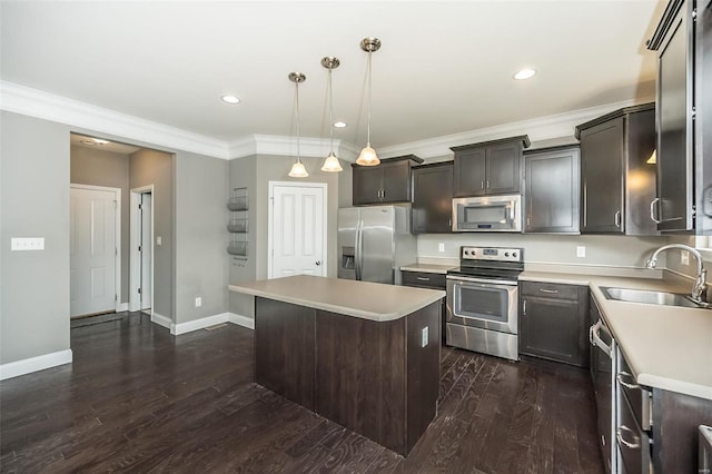 kitchen with light countertops, appliances with stainless steel finishes, a sink, and a center island