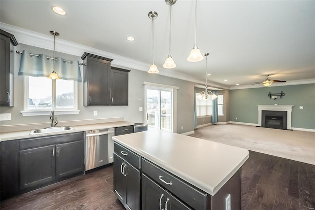 kitchen with crown molding, a fireplace, a sink, and stainless steel dishwasher