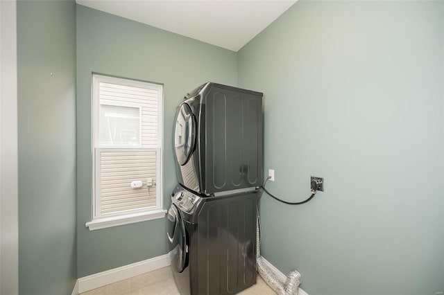 clothes washing area with laundry area, stacked washing maching and dryer, and baseboards