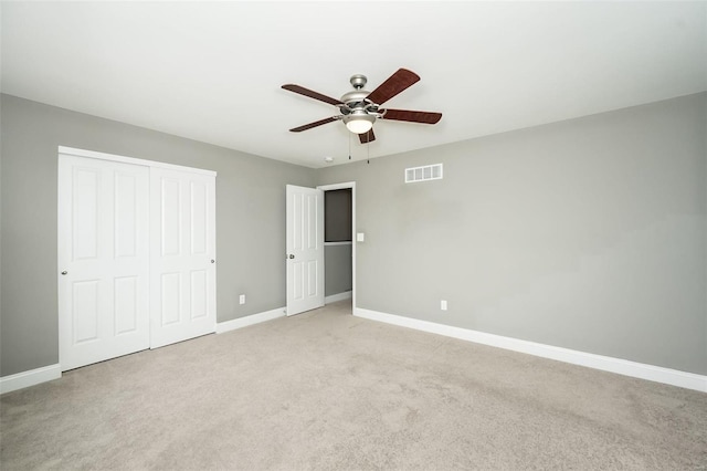 unfurnished bedroom with light carpet, baseboards, visible vents, and a closet