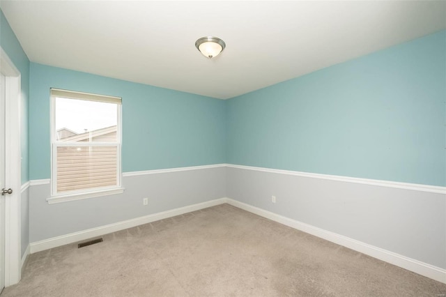 empty room with light carpet, visible vents, and baseboards