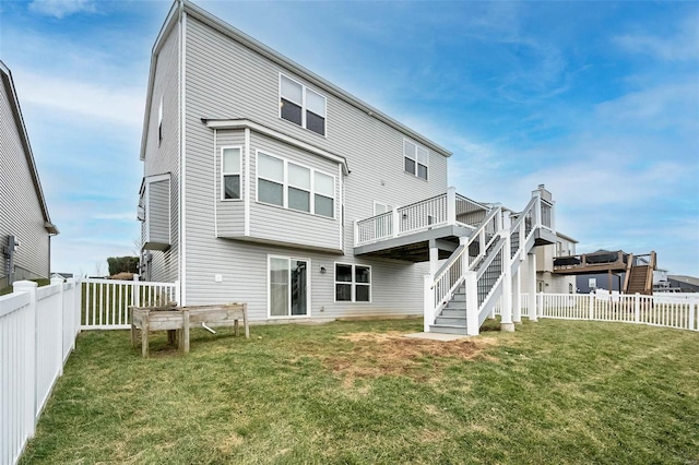 back of property featuring a fenced backyard, a yard, a deck, and stairs