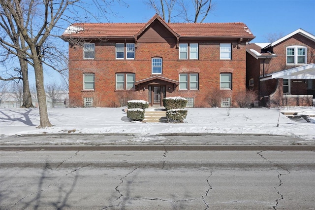 view of front of home with a tile roof and brick siding