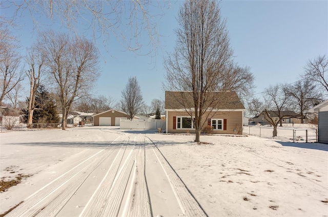 view of front facade with an outdoor structure, driveway, and fence