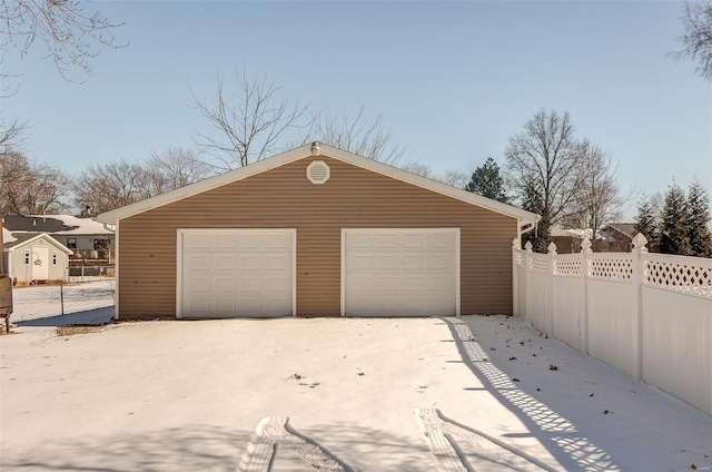 detached garage featuring fence