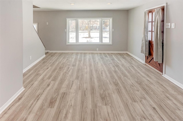 unfurnished living room featuring light wood-style flooring and baseboards