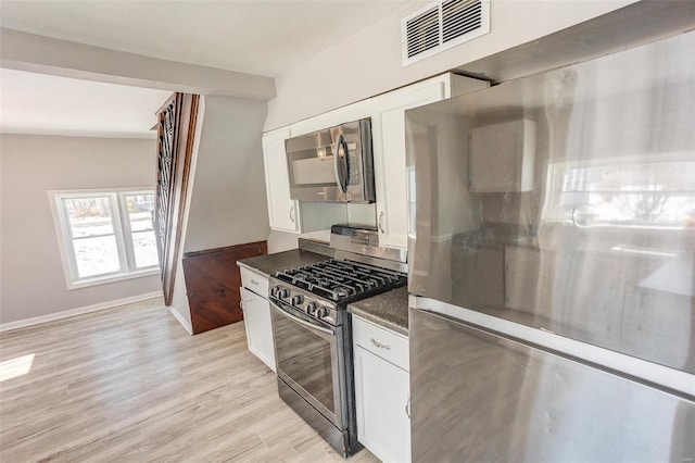 kitchen featuring light wood-style floors, visible vents, appliances with stainless steel finishes, and white cabinets