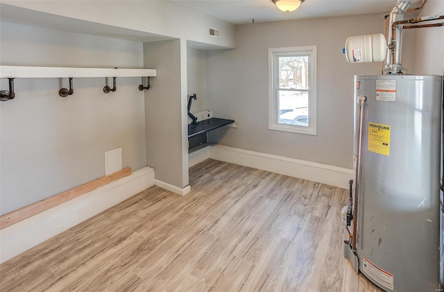 utility room with water heater and visible vents