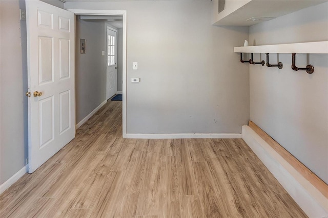 spare room featuring light wood-style floors and baseboards