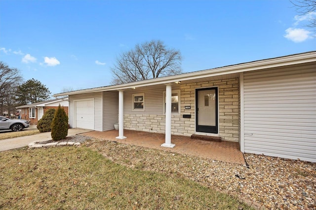 ranch-style house with a garage, stone siding, driveway, and covered porch