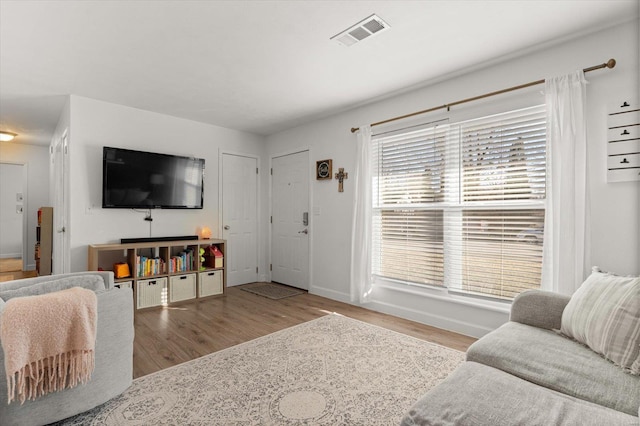 living area with light wood finished floors, baseboards, and visible vents