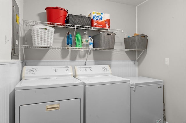 laundry room featuring washing machine and dryer, laundry area, a wainscoted wall, and electric panel