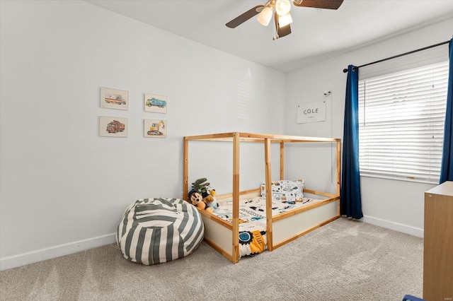 bedroom featuring light carpet, baseboards, and a ceiling fan