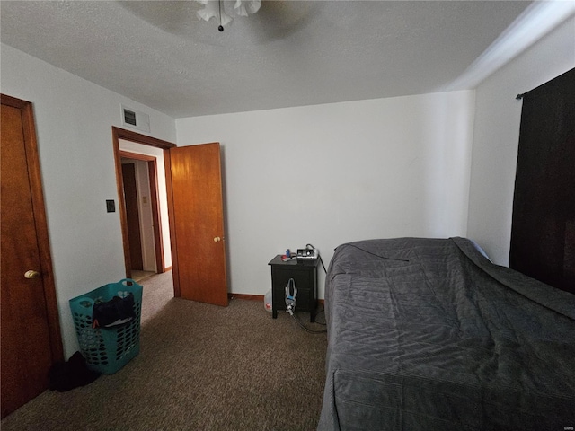 bedroom with a ceiling fan, carpet flooring, visible vents, and a textured ceiling