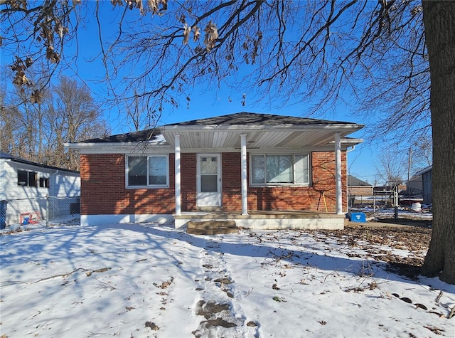 bungalow-style home with brick siding and fence