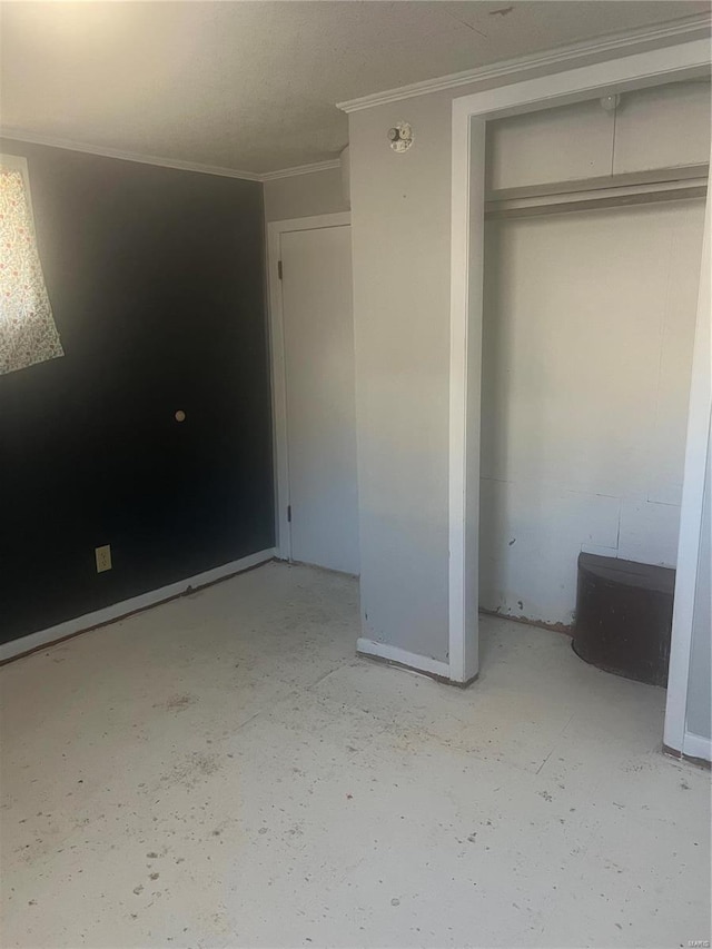 unfurnished bedroom featuring crown molding and a closet