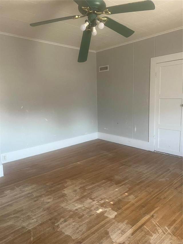 unfurnished room with ornamental molding, wood finished floors, visible vents, and a ceiling fan