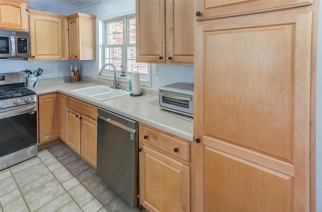 kitchen featuring light tile patterned floors, stainless steel appliances, light countertops, light brown cabinets, and a sink