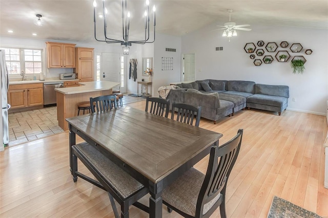 dining room featuring lofted ceiling, light wood-style flooring, and visible vents