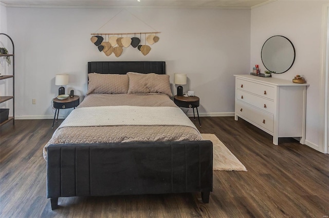 bedroom featuring dark wood-type flooring, ornamental molding, and baseboards