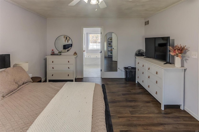 bedroom with dark wood-style floors, crown molding, visible vents, ceiling fan, and ensuite bath