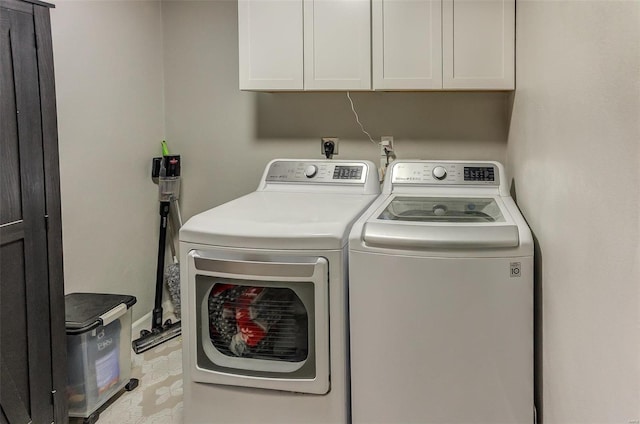 clothes washing area featuring cabinet space and washing machine and dryer