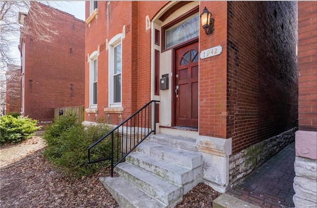 view of exterior entry with brick siding