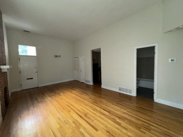 unfurnished living room featuring visible vents, light wood-style flooring, and baseboards