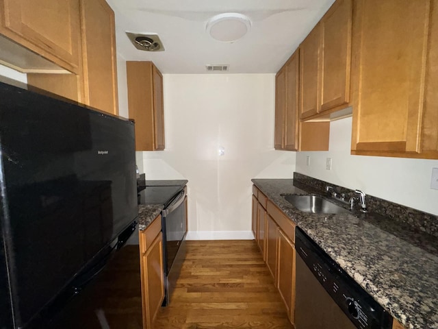 kitchen with wood finished floors, visible vents, a sink, stainless steel dishwasher, and freestanding refrigerator