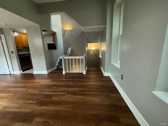 interior space featuring baseboards and dark wood-type flooring