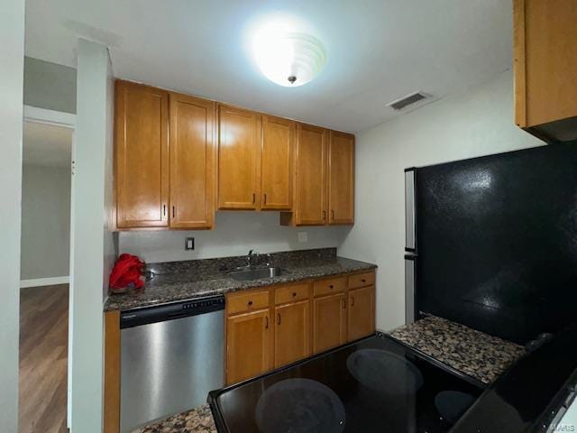 kitchen featuring visible vents, appliances with stainless steel finishes, brown cabinetry, and a sink