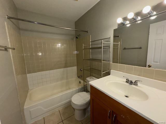 bathroom featuring tile patterned flooring, toilet, vanity, tub / shower combination, and decorative backsplash