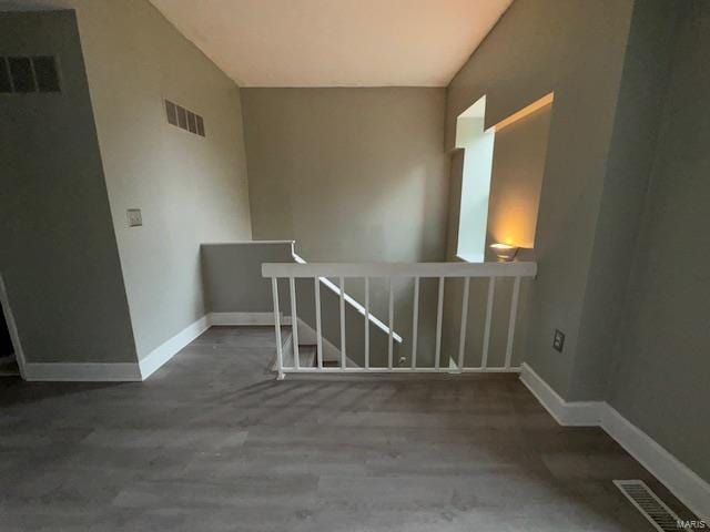 interior space with baseboards, visible vents, and wood finished floors