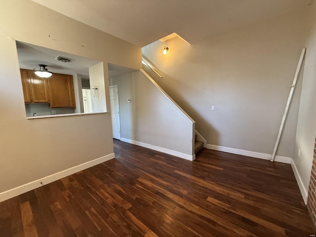 interior space with dark wood-style flooring, stairway, visible vents, and baseboards