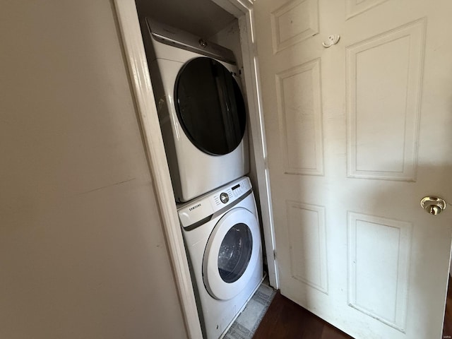 washroom featuring laundry area, dark wood finished floors, and stacked washing maching and dryer