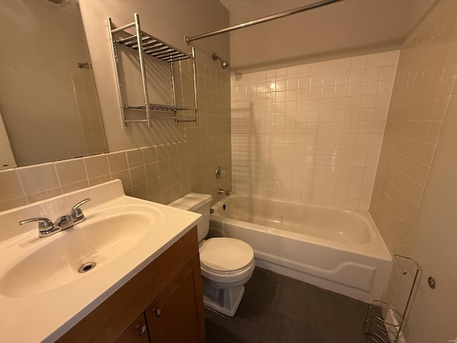 bathroom with tile walls, tasteful backsplash, shower / bath combination, toilet, and vanity