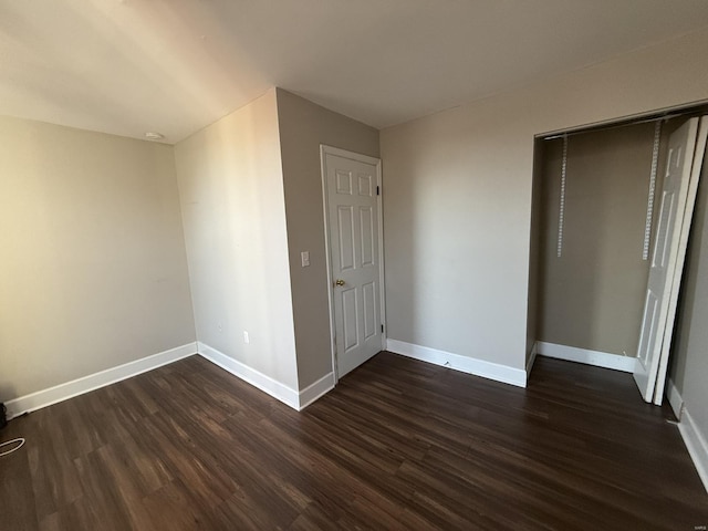 unfurnished bedroom featuring dark wood-type flooring and baseboards