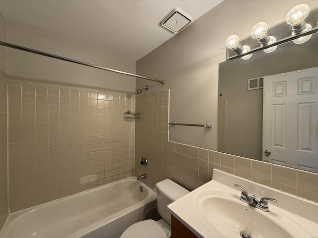 bathroom with visible vents, shower / bathing tub combination, tile walls, and toilet