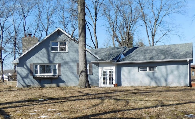 rear view of property with crawl space, french doors, a chimney, and brick siding