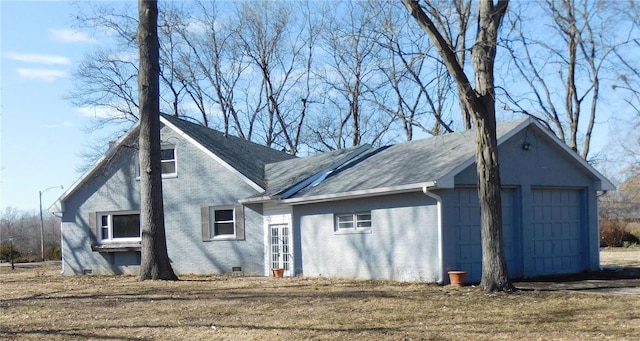 exterior space featuring a shingled roof, crawl space, and brick siding