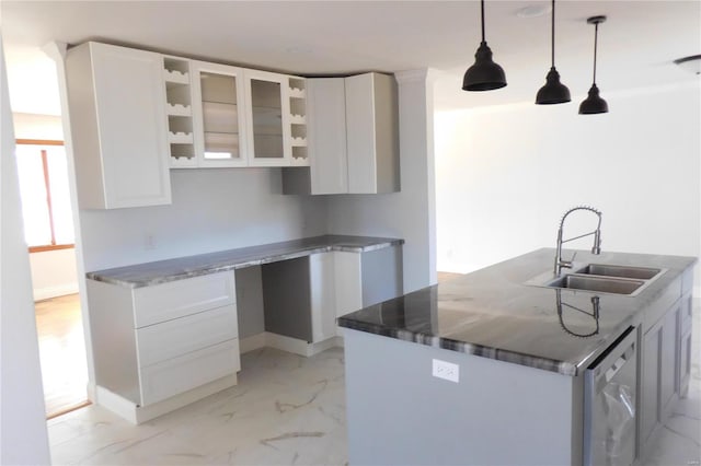 kitchen with pendant lighting, a sink, glass insert cabinets, and white cabinets