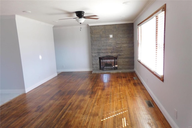 unfurnished living room featuring a fireplace, visible vents, ornamental molding, wood finished floors, and baseboards