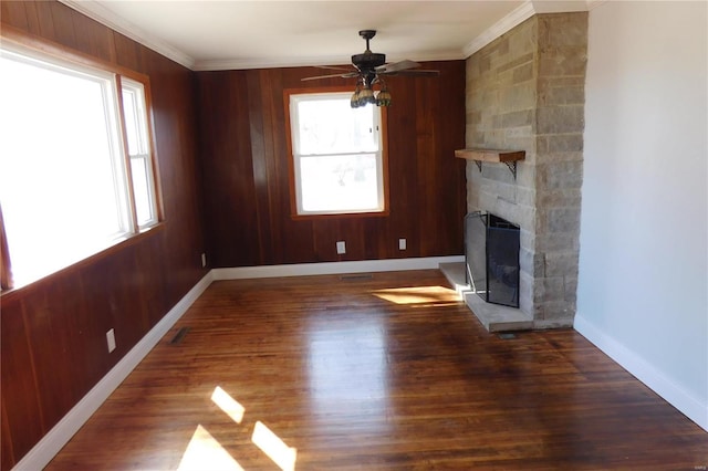 unfurnished living room featuring baseboards, a fireplace, ornamental molding, and dark wood-style flooring