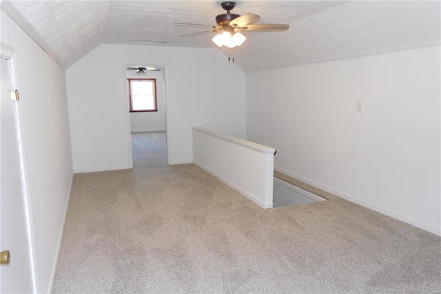 bonus room featuring lofted ceiling, light colored carpet, visible vents, a textured ceiling, and baseboards