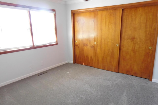 unfurnished bedroom with light carpet, baseboards, visible vents, and a closet