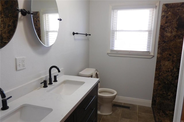 bathroom with double vanity, visible vents, toilet, and a sink