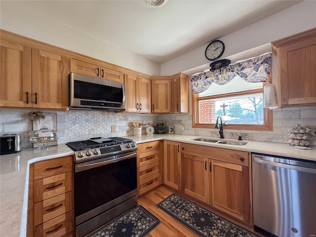 kitchen featuring appliances with stainless steel finishes, light countertops, and a sink