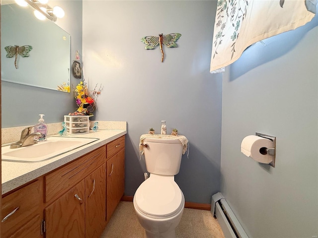 bathroom with a baseboard radiator, vanity, toilet, and baseboards