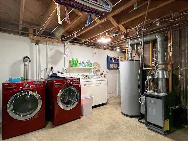 clothes washing area with water heater, laundry area, and washer and dryer